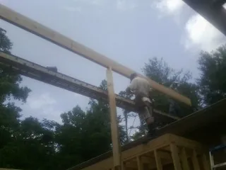 Carpenter setting a ridge beam over a new addition frame — Ice Dam Removal by Roofing Brothers in Grottoes