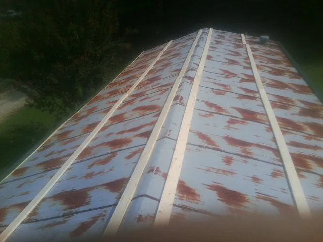 Rusted metal roof panels with new wood purlins before replacement — Storm Damage Roof Repair in Grottoes by Roofing Brothers