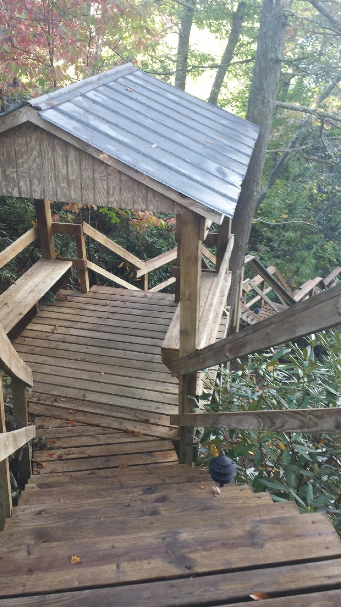 Metal roofed shelter over wooden steps on a wooded walkway — Skylight Repair & Installation work by our crew in Grottoes