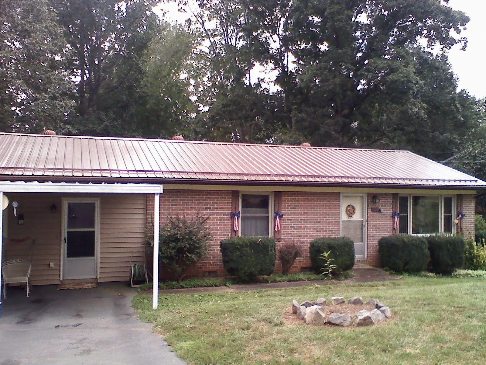 Bronze metal roof and carport on a brick ranch home — Roof Repair work by our crew in Grottoes